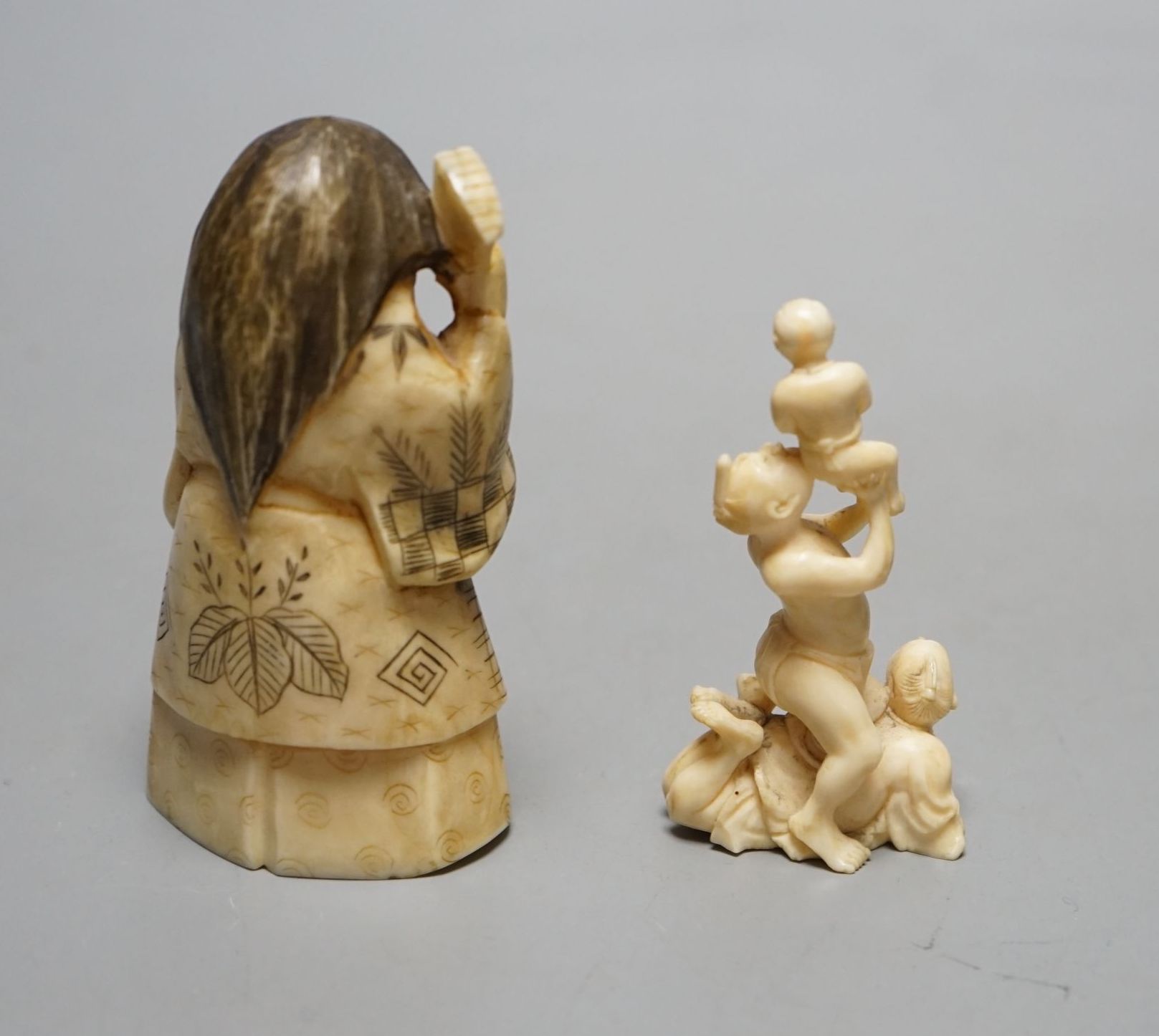 A Japanese face changer, early 20th century, a small okimono of acrobats, Meiji period and an ivory paper knife with lacquer decoration, face changer 8 cms high.